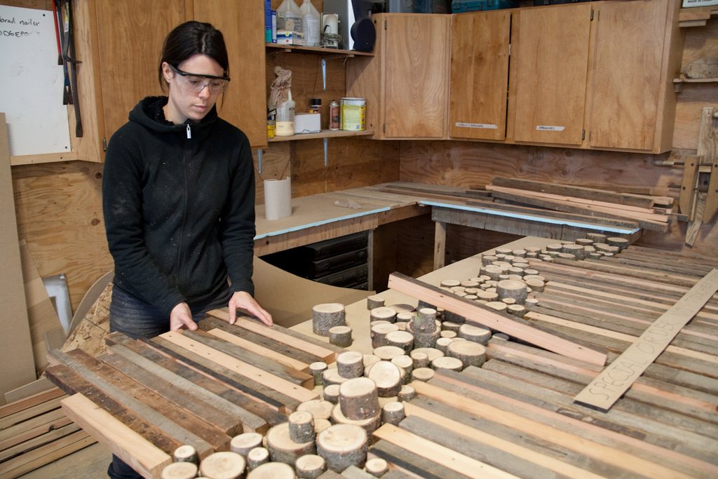 Craftsperson laying out cut wooden pieces on a workshop bench
