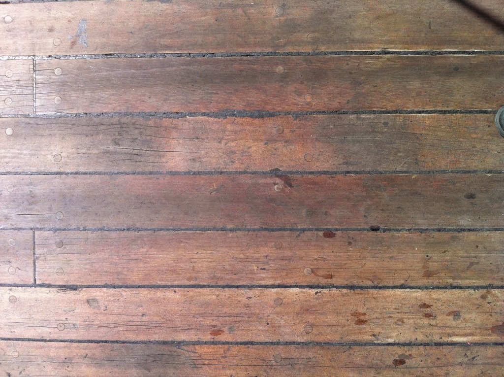 Close view of warm, weathered wooden floorboards with visible grain